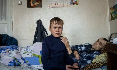 Mykola Svyryd, 70, hugs his son, Bohdan, 13, in a shelter for injured and homeless people in Izium, Ukraine, Sept. 26, 2022.