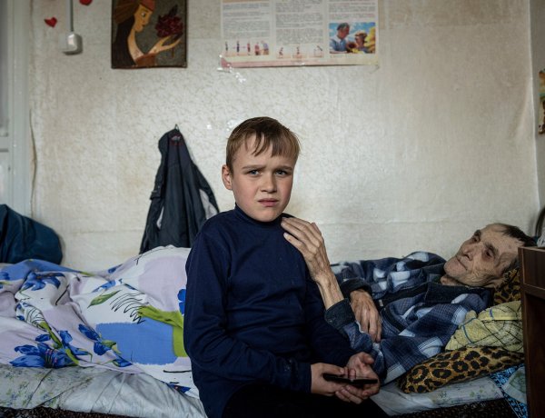 Mykola Svyryd, 70, hugs his son, Bohdan, 13, in a shelter for injured and homeless people in Izium, Ukraine, Sept. 26, 2022.